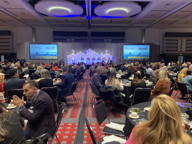 Guests watching a presentation by MIC of Colorado